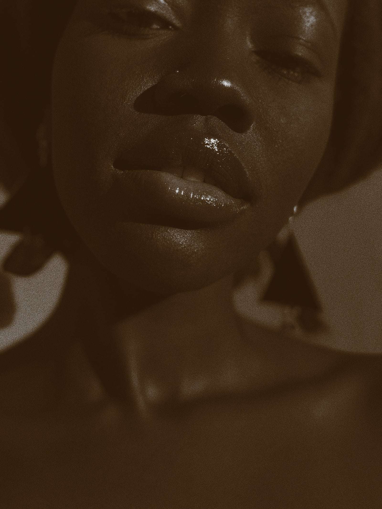 A close crop of a face and shoulders in warm sepia light, from Deun Ivory’s global campaign for Apple