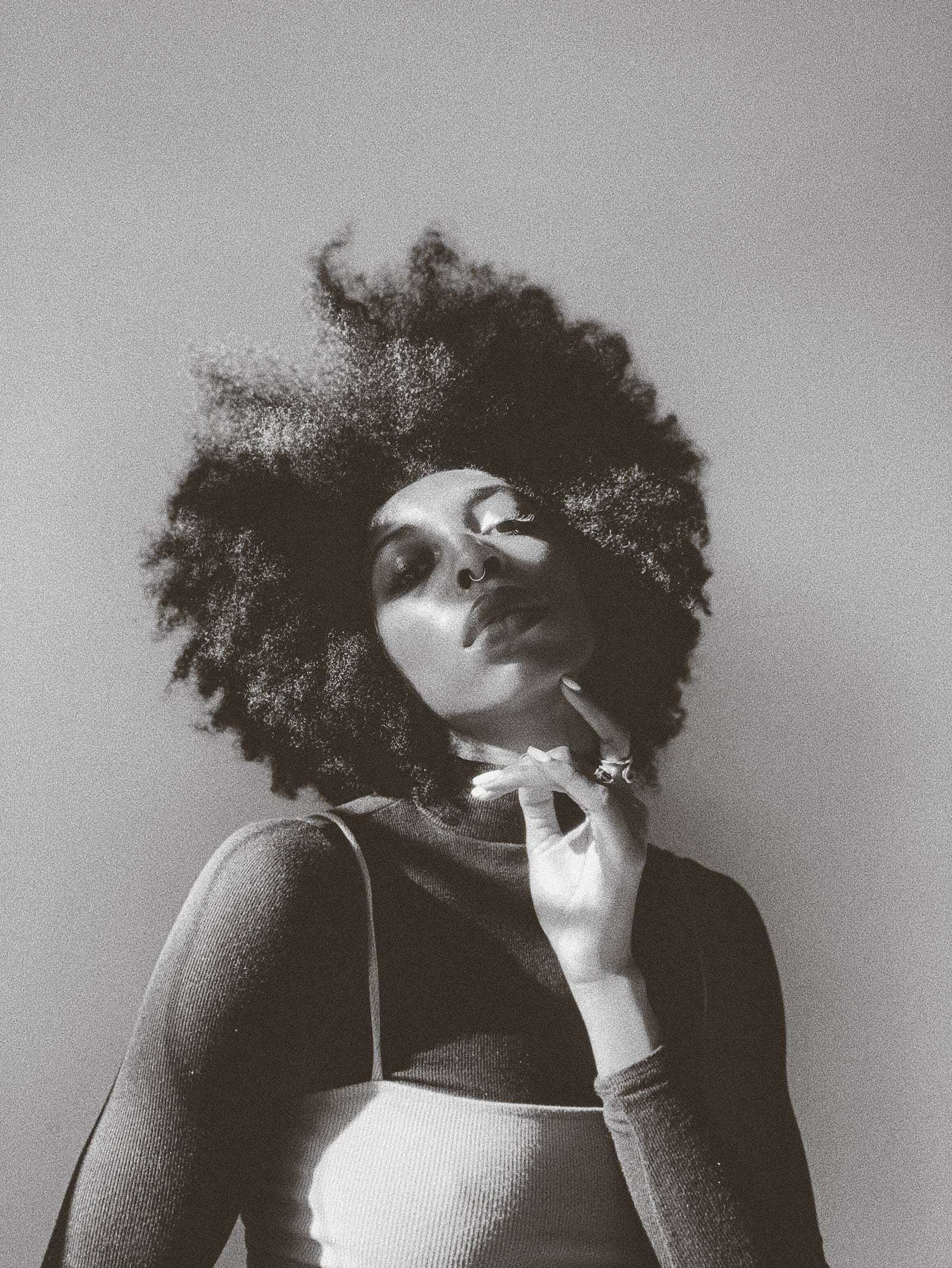 A woman with a full afro, hand at her chin, in black and white, from Deun Ivory’s global campaign for Apple