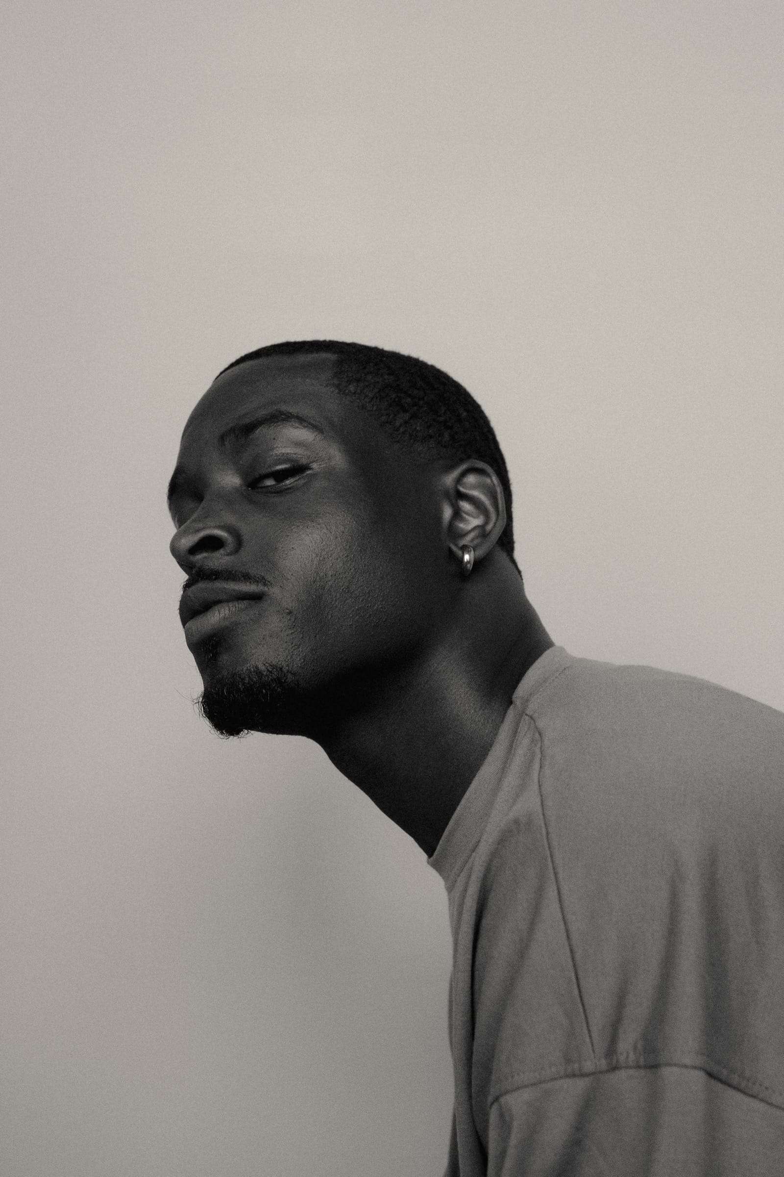 A man looking down at the camera over his shoulder, from Day Dream, a series by Deun Ivory