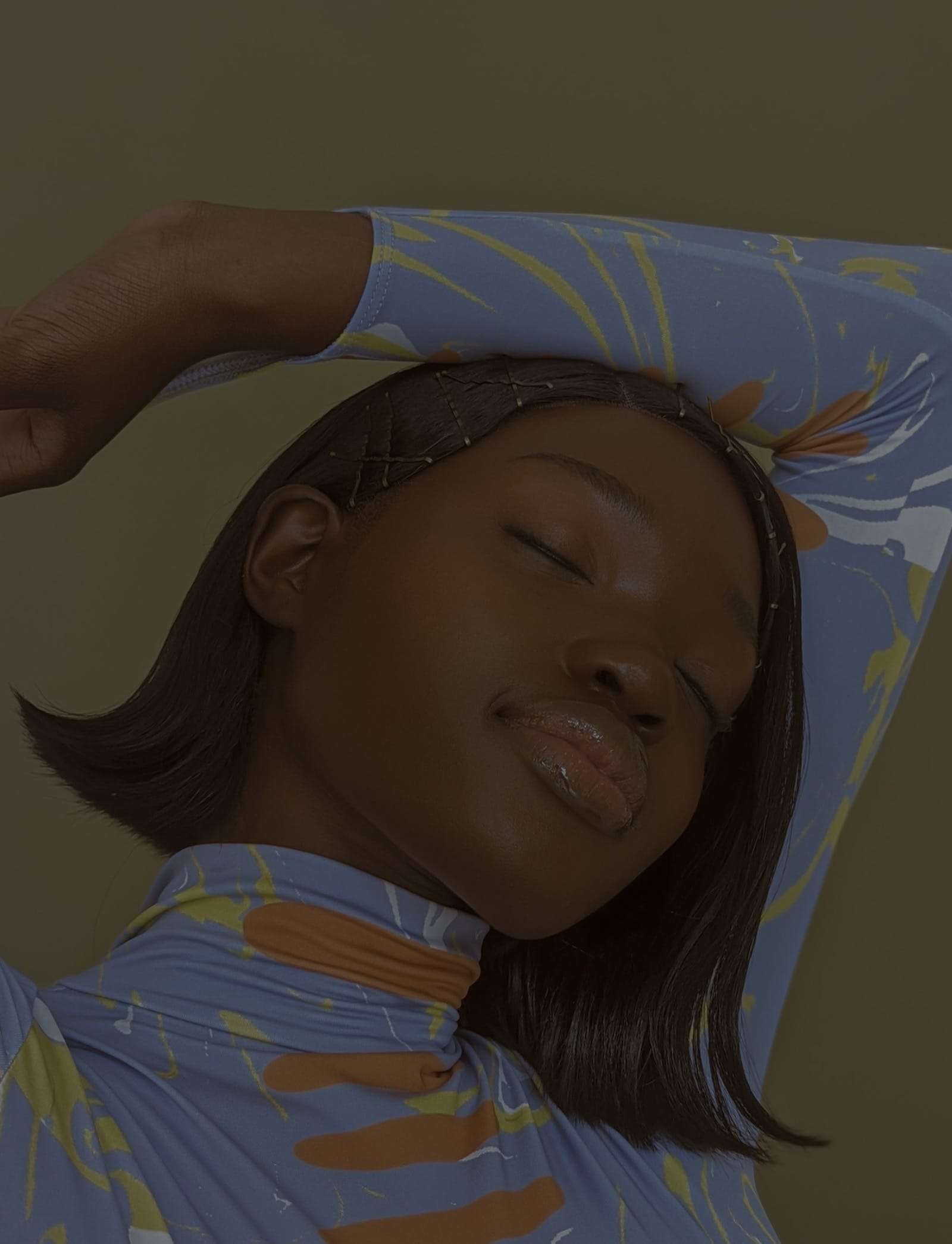 A woman with her eyes closed and an arm over her head, in a patterned top, from Project Douglas, Deun Ivory’s work with Google