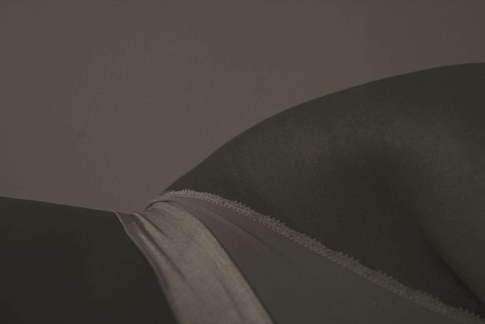 A close crop of a hip and lace in soft sepia light, from Simi, photographed by Deun Ivory for the body